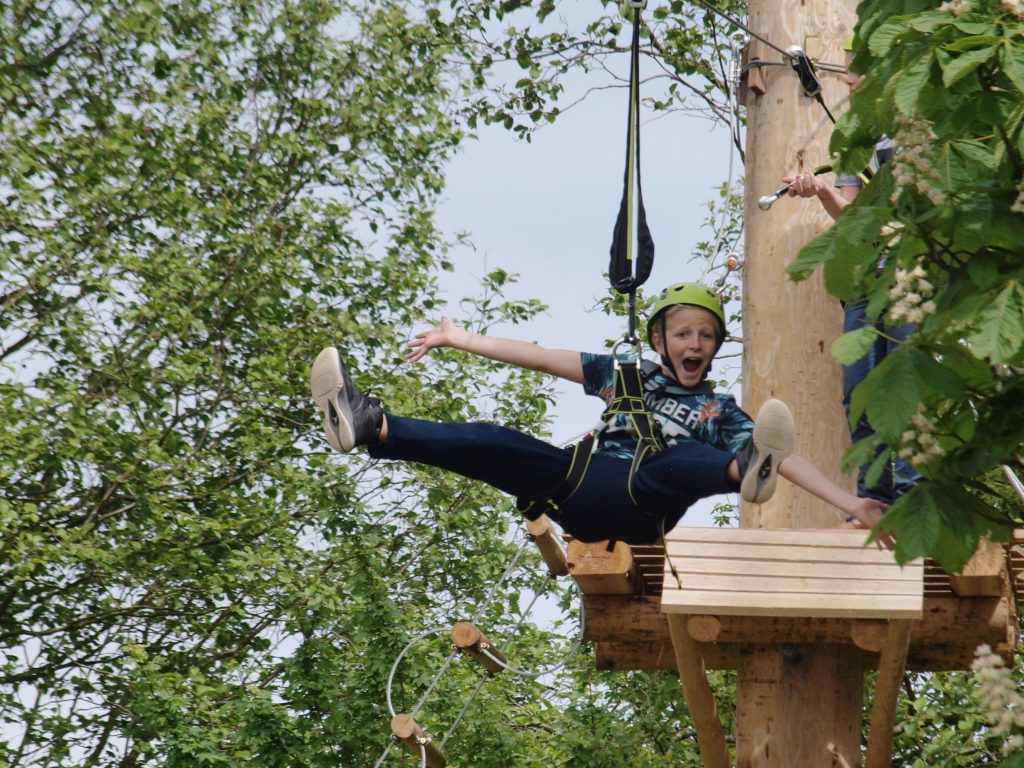 Jongen op kabelbaan (zipline) in klimbos de KlimVallei.